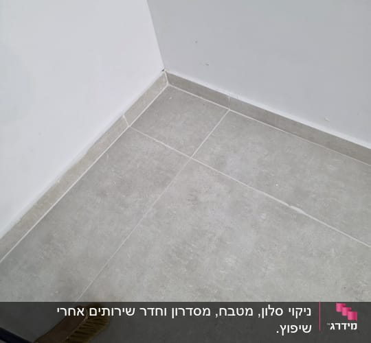 מטאטא על רצפה נקייה ליד קיר לבן